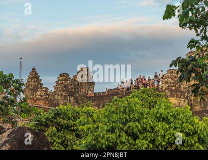 SIEM REAP, KAMBODSCHA - 11. JANUAR 2023 : Touristen auf dem Gipfel des Phnom Bakheng Tempels, die den Sonnenuntergang fotografieren und beobachten. Stockfoto
