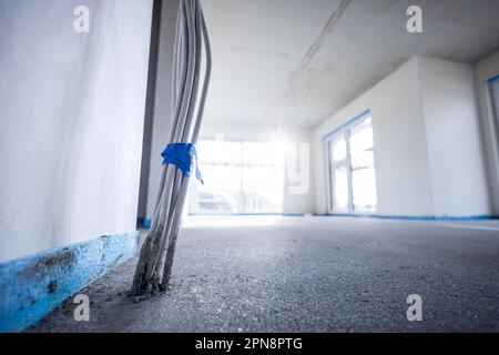 Innenraum eines Gebäudes im Bau, wobei die Verkabelung aus dem Boden austritt Stockfoto