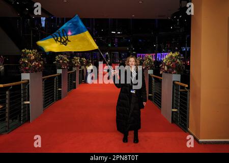 Diana Berg winkt eine ukrainische Flagge, die auf dem roten Teppich für die Abschlusszeremonie und die Preise während des Internationalen Filmfestivals in Berlin am 25. Februar 2023 im Berlinale Palast in Berlin fotografiert wurde. Bild von Julie Edwards. Stockfoto