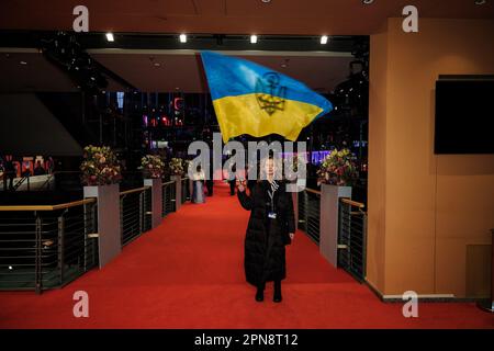 Diana Berg winkt eine ukrainische Flagge, die auf dem roten Teppich für die Abschlusszeremonie und die Preise während des Internationalen Filmfestivals in Berlin am 25. Februar 2023 im Berlinale Palast in Berlin fotografiert wurde. Bild von Julie Edwards. Stockfoto