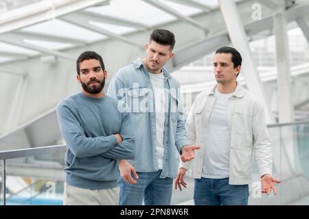 Drei Männliche Freunde, Die Streit Haben Und Zusammen Auf Dem Flughafen Reisen Stockfoto