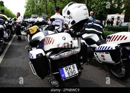 Polizisten und große BMW-Motorräder beim Giro d'Italia-Straßenrennen 2022 in Budapest am 6. Mai. Großaufnahme mit weißem Helm. Viele Fahrräder in der Perspektive Stockfoto