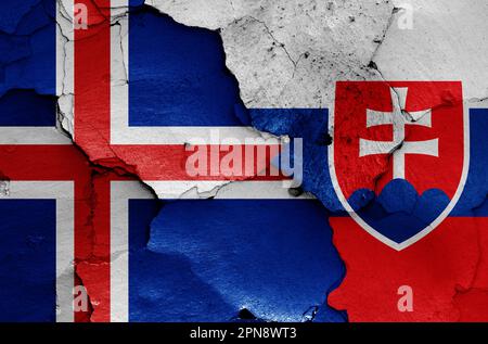 Die Flaggen Islands und der Slowakei sind auf eine gerissene Wand gemalt Stockfoto