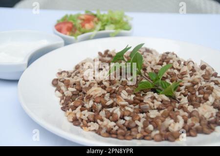 Mucendra Pilav: Traditioneller zyprischer Pilaf aus Linsen und Reis, serviert mit Salat und Joghurt Stockfoto