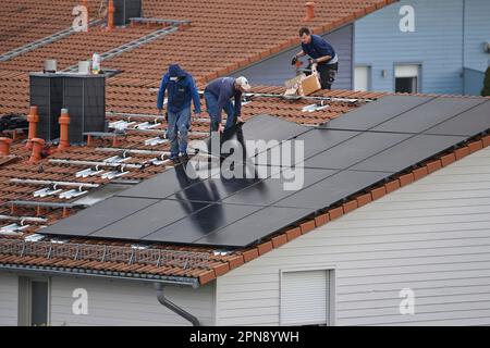 Haare, Deutschland. 17. April 2023. Einzelhaus mit Photovoltaikanlage: Arbeiter, die Solarpaneele auf einem Hausdach installieren. Solarzellen, Solarmodule, Haus, Solarenergie, Solarenergie? Kredit: dpa/Alamy Live News Stockfoto