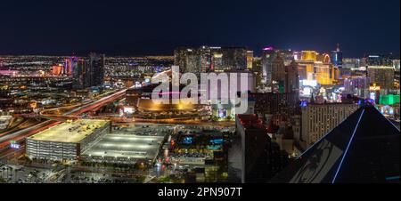 Ein Panoramabild von Las Vegas bei Nacht, mit dem Strip auf der rechten Seite und der T-Mobile Arena auf der linken Seite. Stockfoto