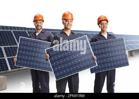 Solarfarm und Arbeiter, die mit isolierten Paneelen auf weißem Hintergrund posieren Stockfoto