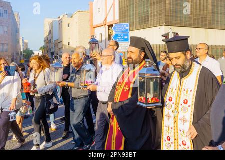 Haifa, Israel - 15. April 2023: Priester und Einheimische tragen das heilige Feuer während einer Parade am Heiligen Samstag, die Teil der orthodoxen Osterfeier in Haifa ist, Stockfoto