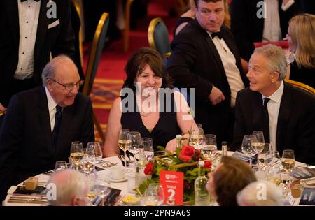 (Von links nach rechts) ehemaliger US-Senator George Mitchell, US-Botschafter in Irland Claire Cronin und ehemaliger Premierminister Sir Tony Blair nehmen an einem Bankett im Rathaus von Belfast Teil, Im Rahmen einer dreitägigen internationalen Konferenz an der Queen's University Belfast anlässlich des 25. Jahrestags des Abkommens zwischen Belfast und Karfreitag. Foto: Montag, 17. April 2023. Stockfoto