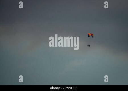 Mann mit kleinem Fahrrad und Fallschirm in Farbe, frischer Himmel in Nordböhmen Stockfoto