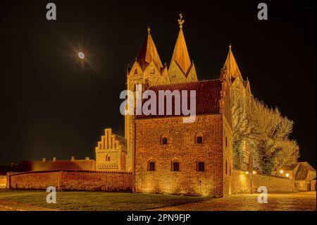 Die Türme der Kalundborg-Frauenkirche beleuchtet in der Abenddämmerung, Kaulundborg, Dänemark, 4. April 2023 Stockfoto