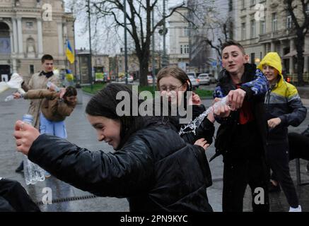 Lemberg, Ukraine. 17. April 2023. Die Ukrainer gießen sich auf der Straße im Stadtzentrum inmitten der russischen Invasion in die Ukraine gegenseitig Wasser. Der Brauch des Wassertauchens ist ein uralter Ritus der Frühjahrspülung, der am Ostermontag stattfindet. Kredit: SOPA Images Limited/Alamy Live News Stockfoto