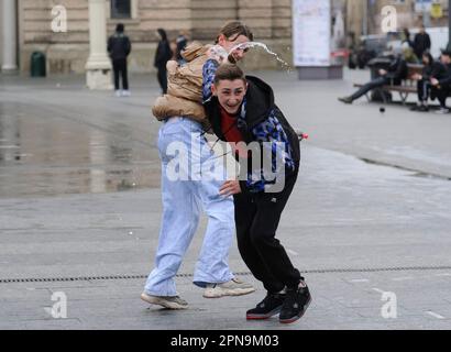 Lemberg, Ukraine. 17. April 2023. Die Ukrainer gießen sich auf der Straße im Stadtzentrum inmitten der russischen Invasion in die Ukraine gegenseitig Wasser. Der Brauch des Wassertauchens ist ein uralter Ritus der Frühjahrspülung, der am Ostermontag stattfindet. Kredit: SOPA Images Limited/Alamy Live News Stockfoto