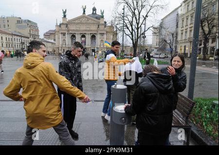 Lemberg, Ukraine. 17. April 2023. Die Ukrainer gießen sich auf der Straße im Stadtzentrum inmitten der russischen Invasion in die Ukraine gegenseitig Wasser. Der Brauch des Wassertauchens ist ein uralter Ritus der Frühjahrspülung, der am Ostermontag stattfindet. Kredit: SOPA Images Limited/Alamy Live News Stockfoto