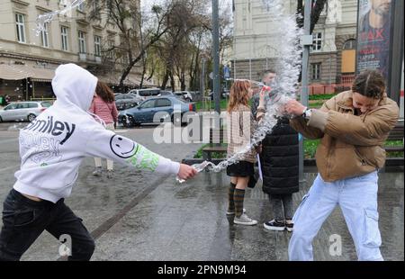 Lemberg, Ukraine. 17. April 2023. Die Ukrainer gießen sich auf der Straße im Stadtzentrum inmitten der russischen Invasion in die Ukraine gegenseitig Wasser. Der Brauch des Wassertauchens ist ein uralter Ritus der Frühjahrspülung, der am Ostermontag stattfindet. (Foto: Mykola Tys/SOPA Images/Sipa USA) Guthaben: SIPA USA/Alamy Live News Stockfoto