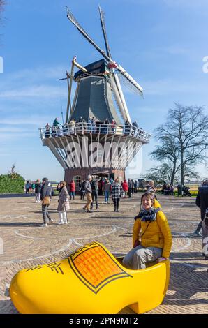 Junge Frau, die in Riesenclog posiert, Gartenanlage Keukenhof, Lisse, Südholland (Zuid-Holland), Königreich der Niederlande Stockfoto