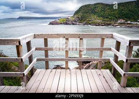 Holzsteg und Geländer mit Blick auf Narrows und Fort Amherst Lighthouse vom Battery Hiking Trail in St. John's Neufundland Kanada. Stockfoto