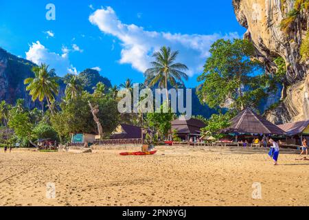 Gebäude und Palmen in der Nähe von Felsen in Tonsai Bay, Railay Beach, Ao Nang, Krabi, Thailand. Stockfoto