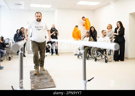 Wynnyky, Ukraine. 14. April 2023. Besucher beobachten, wie ein verwundeter ukrainischer Krieger bei der Eröffnung des Superhumans Prothetik and Rehabilitation Medical Center, 14. April 2023 in Lemberg, Ukraine, fortgeschrittene prothetische Gliedmaßen demonstriert. Kredit: Ukrainischer Ratsvorsitz/Pressestelle Des Ukrainischen Präsidenten/Alamy Live News Stockfoto