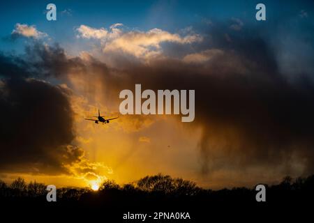 Flugzeuglandung, nachdem der Flughafen wegen starkem Wind, Rückstand von Flugzeugen, die auf die Landung warten, geschlossen wurde, atemberaubende Sonnenuntergänge am frühen Abend im Winter Stockfoto