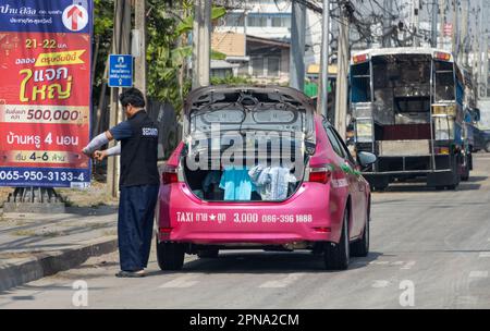 SAMUT PRAKAN, THAILAND, JANUAR 21 2023, Ein Taxifahrer reinigt den Gepäckraum eines Taxifahrzeugs Stockfoto