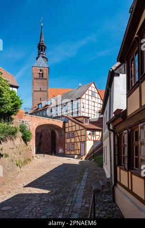 Gasse vom Hafen zur Altstadt, Kopfsteinpflaster und Fachwerkhäuser, St. Die Stephan-Kirche hinten, Tangermuende, Sachsen-Anhalt, Deutschland Stockfoto