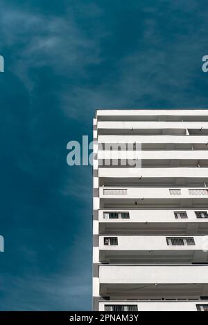 Modernes Wohngebäude mit weißen Balkonen. Betonarchitektur vor dem blauen Himmel Stockfoto