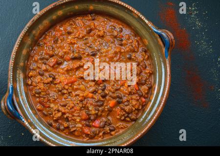 Black Bean Beef Chili Con Carne in einem großen Tontopf Stockfoto