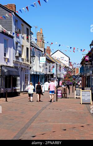 Touristen laufen entlang einer Einkaufsstraße in der Altstadt, Sidmouth, Devon, Großbritannien, Europa. Stockfoto