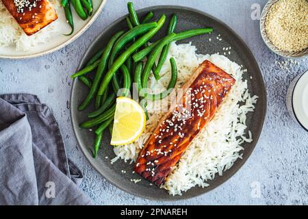 Honig-Teriyaki-Lachs mit grünen Bohnen und Reis, Draufsicht. Asiatische Küche nach Rezept. Stockfoto