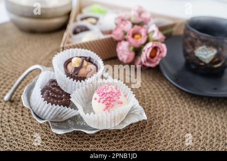 Verschiedene handgemachte Süßigkeiten, Schweizer Pralinen in Geschenkbox, verschiedene luxuriöse Pralinen aus dunkler und milchhaltiger Bio-Schokolade, süßes Dessertessen als Urlaub Stockfoto