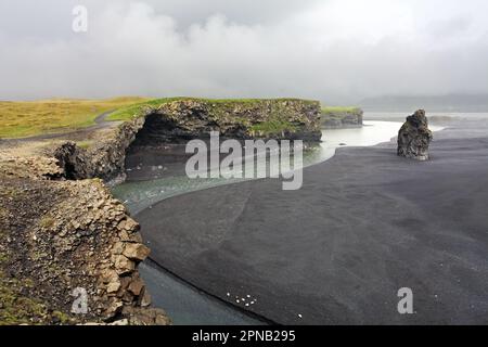 Der schwarze Sand Strand Reynisfjara und der Berg Reynisfjall von Dyrhólaey Vorgebirge in der südlichen Küste von Island. Stockfoto