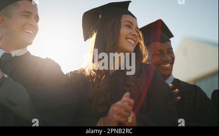 Es hat eine Weile gedauert, aber wir haben es geschafft. Eine Gruppe fröhlicher junger Studenten, die tagsüber am Abschlusstag zusammen im Freien stehen. Stockfoto