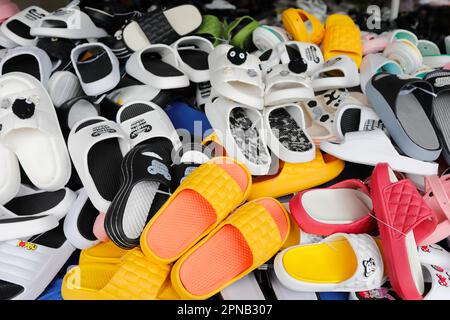 Farbenfrohe Kunststoffsandalen zum Verkauf auf einem Markt. Tan Chau. Vietnam. Stockfoto