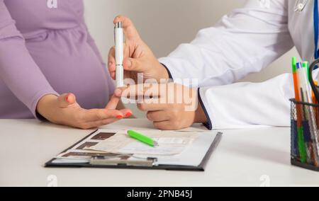 Messung der Blutviskosität und des Blutzuckers bei einem schwangeren Mädchen. Hoher und niedriger Blutzucker während der Schwangerschaft. Stockfoto