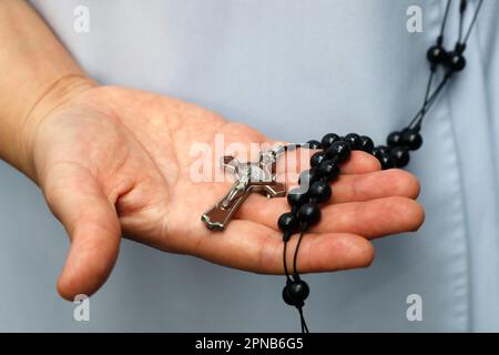Die Dominikanische Nonne bezahlt die Rosenkranz-Perlen. Nahaufnahme der Hände. Ho-Chi-Minh-Stadt. Vietnam. Stockfoto