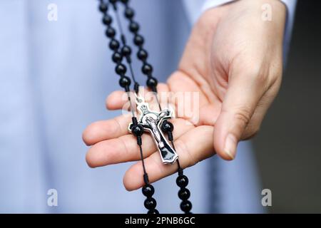 Die Dominikanische Nonne bezahlt die Rosenkranz-Perlen. Nahaufnahme der Hände. Ho-Chi-Minh-Stadt. Vietnam. Stockfoto