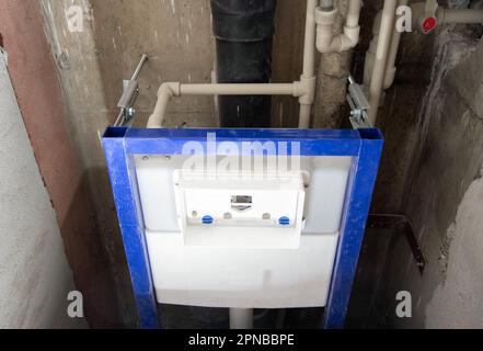 Installation einer neuen wandmontierten Toilette mit Wasserabflussvorrichtung. Stockfoto