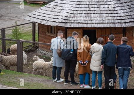 Lemberg, Ukraine. 17. April 2023. Erwachsene und Kinder stehen in der Nähe eines Gehege mit Schafen Trotz des Krieges feiern die Menschen den zweiten Ostertag und besuchen den Park mit Vieh, um sie zu füttern, Spaß zu haben und Zeit mit der Familie zu verbringen (Foto von Olena Znak/SOPA Images/Sipa USA). Guthaben: SIPA USA/Alamy Live News Stockfoto