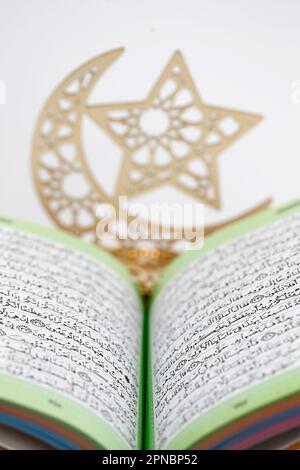 Offener heiliger Koran ( Kuran ) und Halbmond und Stern, Symbole des islamischen Glaubens. Muslimische Symbole. Stockfoto