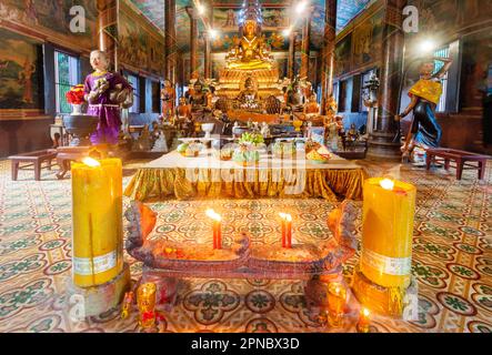 Wichtige historische Pagode von Khmer, umgeben von Gärten, im Zentrum der Stadt. Kunstvoll dekoriert mit großen beleuchteten gelben Wachskerzen und Weihrauch sti Stockfoto