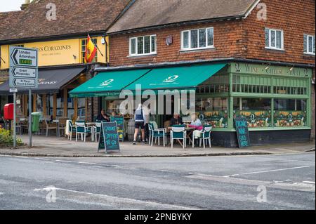 Gäste, die an den Tischen auf dem Bürgersteig sitzen, genießen Erfrischungen in der No2 Pound Street, einem Käse- und Weinladen und Delikatessen. Wendover, Buckinghamshire, England Stockfoto