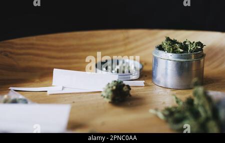 Es wird hier gleich grüner. Getrocknetes Marihuana in einer Dose und Papier. Stockfoto