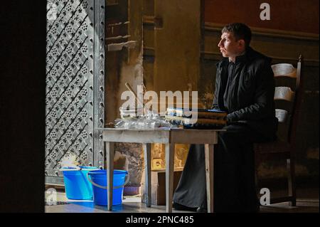 LEMBERG, UKRAINE - 15. APRIL 2023 - Ein Priester wird während des Segens der Osterkörbe im Bernardinenkloster am Heiligen Samstag, Lemberg, im Westen abgebildet Stockfoto
