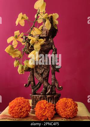 Messingidol von Lord Krishna dekoriert mit Marigold und Amaltas/Goldene Duschblumen/Vishu/Vishu Kani/Kerala Stockfoto