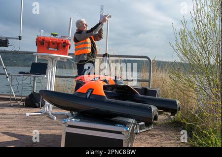 Aseleben, Deutschland. 18. April 2023. Jens Hensse macht den tragbaren Subprofiler einsatzbereit. Dieses Gerät kann Materialien mehrere Meter unterhalb der Sedimentschicht am Grund des Sees lokalisieren. Diese moderne Technologie wird zum ersten Mal bei der Suche nach archäologischen Schätzen am Sueser See eingesetzt. Kredit: Heiko Rebsch/dpa/Alamy Live News Stockfoto