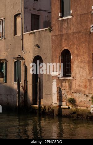 Blick auf Gebäude mit roten Mauern über dem Kanal in der Altstadt an sonnigen Tagen Stockfoto