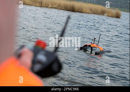 Aseleben, Deutschland. 18. April 2023. Die Sonobot Schwimmdrohne wird verwendet. Das Gerät scannt den Grund des Sees unabhängig mit Sonar und kann Bilder davon anzeigen. Diese moderne Technologie wird zum ersten Mal bei der Suche nach archäologischen Schätzen unter Wasser auf dem Grund des Lake Suess eingesetzt. Kredit: Heiko Rebsch/dpa/Alamy Live News Stockfoto