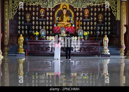 Phat Quang buddhistischer Tempel. Siddhartha Gautama, der Shakyamuni Buddha. Ein junges Paar betet. Chau Doc. Vietnam. Stockfoto