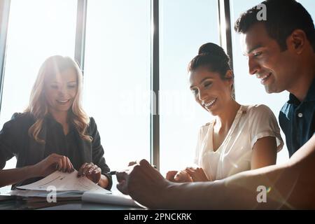 Überprüfung des aktuellen Zustands ihrer Finanzen. Ein junges Paar trifft sich mit einem Finanzplaner in einem modernen Büro. Stockfoto